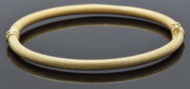 A 9ct gold bangle with a textured finish, 5.4g
