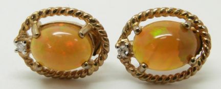 A pair of 9ct gold earrings set with an Indonesian opal and diamonds to each, 2.5g
