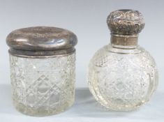 Two cut glass dressing table pots with embossed silver tops, height of taller 11.5cm