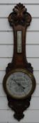 Early 20thC carved oak advertising aneroid barometer, the painted dial 'with compliments from