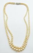 A two-strand cultured pearl necklace with 9ct white gold clasp set with a diamond