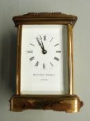 Matthew Norman of London 20thC brass carriage clock in corniche style case, the enamel white Roman