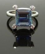 An 18ct white gold ring set with and emerald cut aquamarine and four diamonds, size N, 5.47g