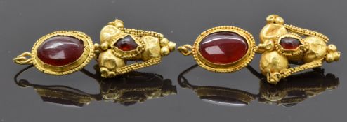 A pair of Roman yellow metal earrings set with garnets