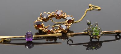 A bar brooch set with an amethyst, a gilt brooch set with garnets and another brooch
