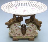 Pierced ceramic centrepiece with brass figural putti supports and masked goat decoration raised on