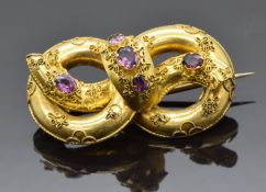 Victorian Etruscan Revival knot brooch set with foiled garnets, verso a small glass compartment