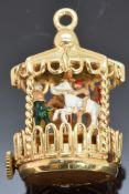 A 14k gold carousel with enamel decoration and a clockwork mechanism, 18.4g
