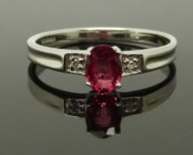 A 9ct white gold ring set with an oval cut synthetic ruby of approximately 0.5ct and diamonds,
