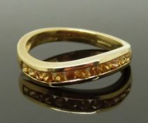 A 9ct gold ring set with yellow sapphires, size N, 2.82g