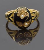 Victorian mourning ring set with seed pearls in the form of a flower on black enamel ground, with