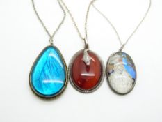 A silver pendant set with agate with snake decoration and two butterfly wing pendants
