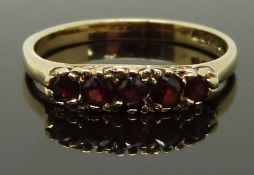 A 9ct gold ring set with garnets, size Q/R, 2.32g