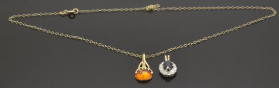 A 9ct gold pendant set with pressed amber and another 9ct gold pendant set with a sapphire, 4g