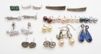 A collection of silver earrings including pearl and cubic zirconia