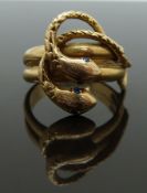 An 18k gold ring in the form of two snakes set with sapphire eyes, size K, 5.84g