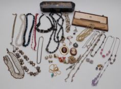 A collection of costume jewellery including brooches, beaded necklaces, Japanese lacquer box etc
