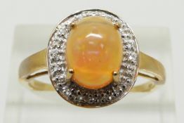 A 9ct gold ring set with an oval Indonesian opal cabochon surrounded by white sapphires, 3.1g,