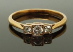 A yellow metal ring set with three diamonds in square settings, size L/M, 1.83g