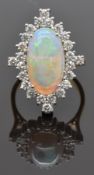 An 18ct gold ring set with a large oval opal cabochon measuring approximately 4ct surrounded by 24