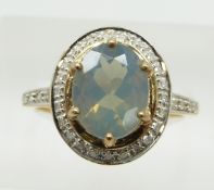 A 9ct gold ring set with an oval cut green fire opal surrounded by diamonds, 3.3g, size N