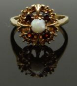 A 9ct gold ring set with an opal and garnets, size L, 2.72g