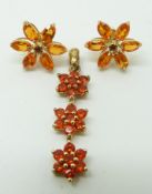 A 9ct gold pendant set with round cut fire opals in three clusters and a pair of 9ct gold earrings