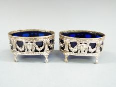 Pair of Victorian hallmarked silver salts with blue glass liners, raised on four feet, London 1900