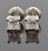 A pair of platinum earrings each set with an emerald cut diamond of approximately 0.4ct, with GIA