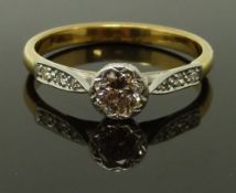 An 18ct gold ring set with a round cut diamond of approximately 0.6ct with diamond encrusted