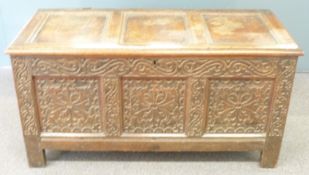 An 18thC oak trunk with carved decoration to the front and sides and panelled lid, W126 x D55 x