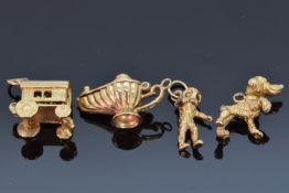 Four 9ct gold charms including a dog, astronaut, caravan, lamp, etc, 11.2g