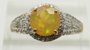 A 9ct gold ring set with a round cut Indonesian opal and zircons, 2.8g, size S