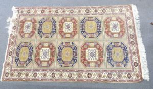 Turkoman rug with geometric design containing ten central guls within a floral border, on beige
