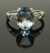 A 9ct white gold ring set with an oval cut aquamarine and diamonds, size J, 2.00g