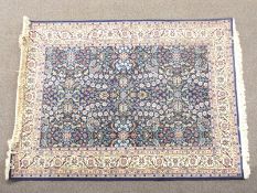 Persian design rug with deep blue ground, arabesque meandering vine pattern and cream border, 175