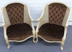 Pair of Continental style bergere armchairs with cream painted frames and button back upholstery.