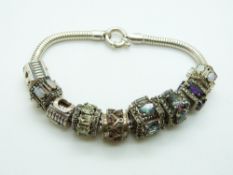 A silver charm bracelet with various charms including topaz, opal, quartz, amethyst, etc
