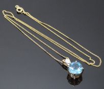 A 9ct gold pendant set with a blue topaz and diamond on 9ct gold chain, 3g