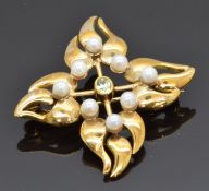 A 9ct gold brooch set with peridot and pearls in a stylised foliate design, 7.7g