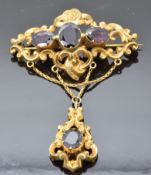 Victorian brooch with scrolling decoration set with large oval cut garnets, 5 x 7.5cm