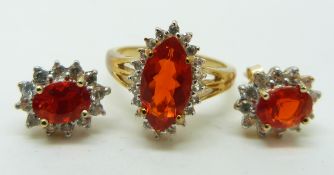 A pair of 9ct gold earrings set with oval cut Queretaro cherry fire opals and white sapphires and