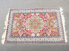 Turkoman rug with geometric design and large central medallion on a red ground within a floral