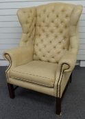 Georgian style cream leather or similar wing backed armchair raised on reeded legs.