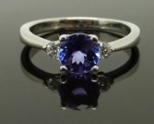 An 18ct white gold ring set with a round cut tanzanite and two round cut diamonds, size K, 2.90g