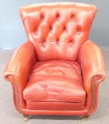 Chesterfield red leather button back armchair raised on wooden legs and brass castors