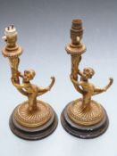 Pair of gilt table lamps formed as putti on a trumpet shaped stem, height 33cm