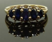 A 9ct gold ring set with five graduated sapphires, size T, 3.36g