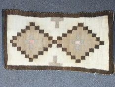North American First Nation rug with geometric brown design on a beige ground, 95 x 52cm