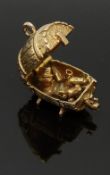 A 9ct gold charm depicting a man drunk in a barrel, 5.6g